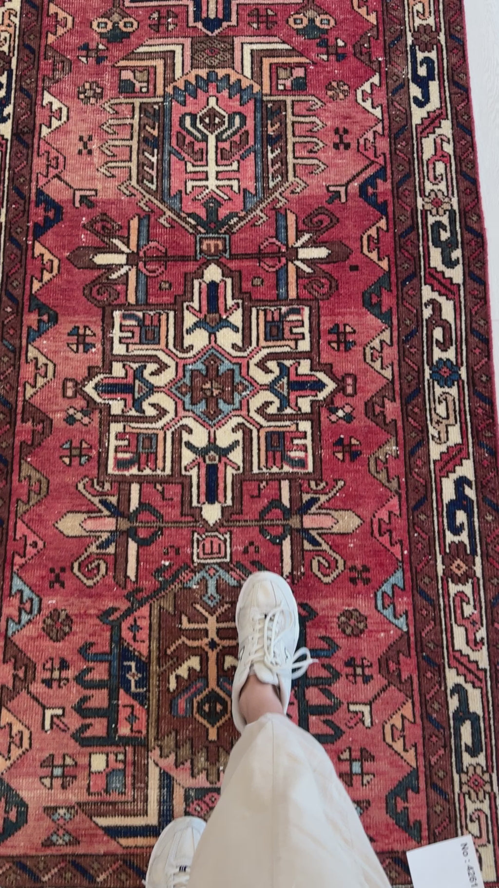 Close-up of foot on Hand-Knotted Antique Wool Runner Rug – 14' 9" x 3' 4", emphasizing detailed motifs and rich red and blue color palette.
