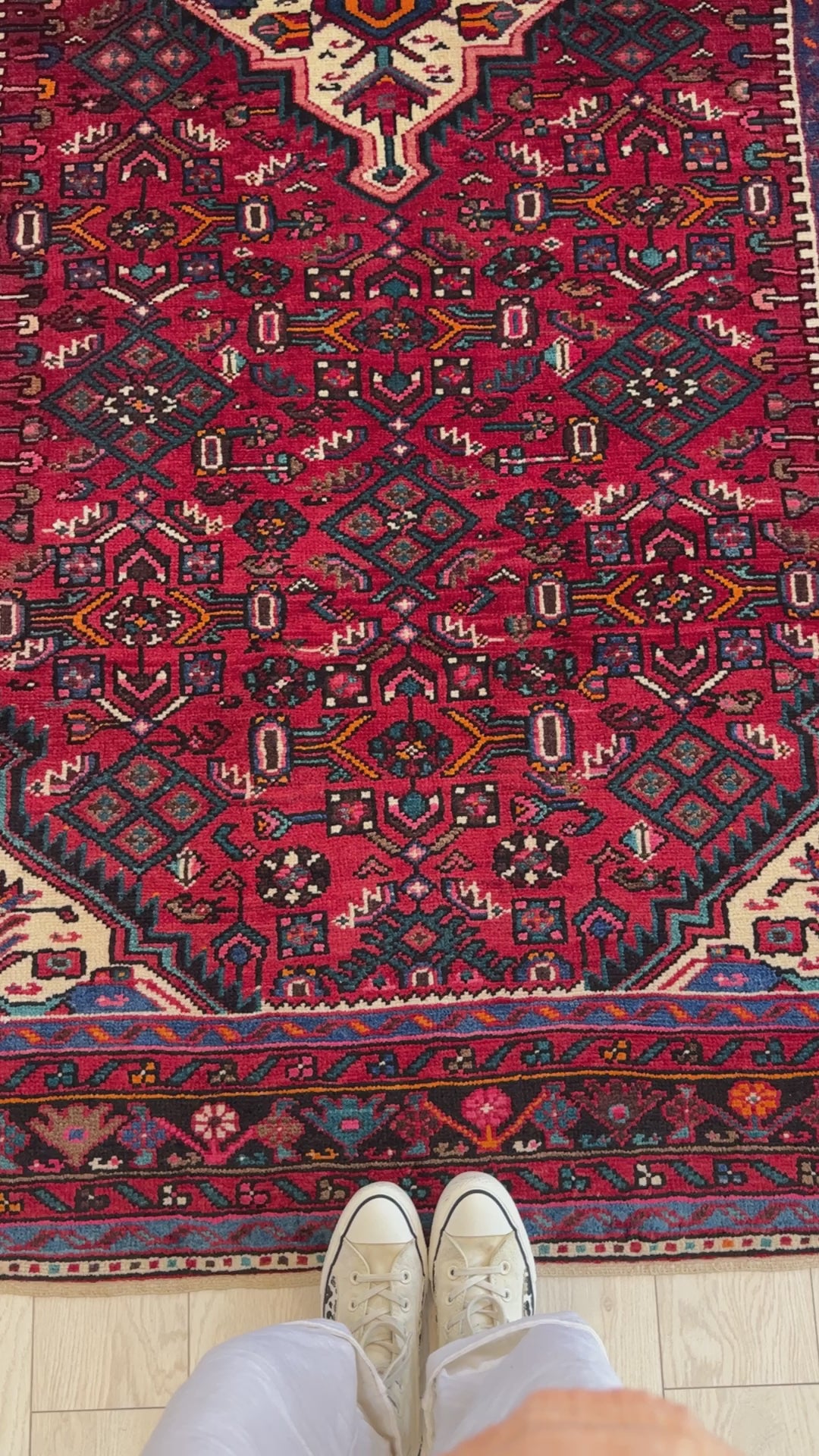 Top-down view of Hand-Knotted Vintage Wool Area Rug – 9' 2" x 5' 2" with shoes for scale, emphasizing its size and intricate pattern.