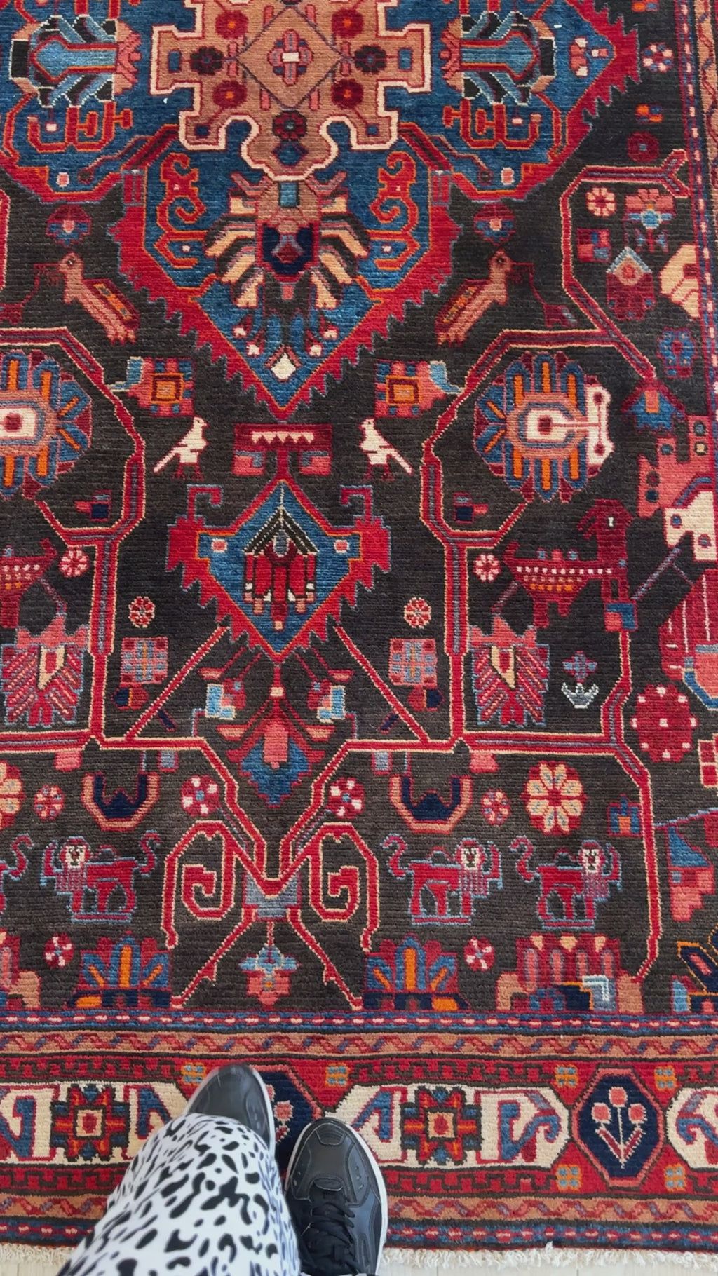 Detailed view of lower section of vintage wool rug 9' 7" x 5' 2" with tribal patterns and rich color contrasts in red, blue, and black.