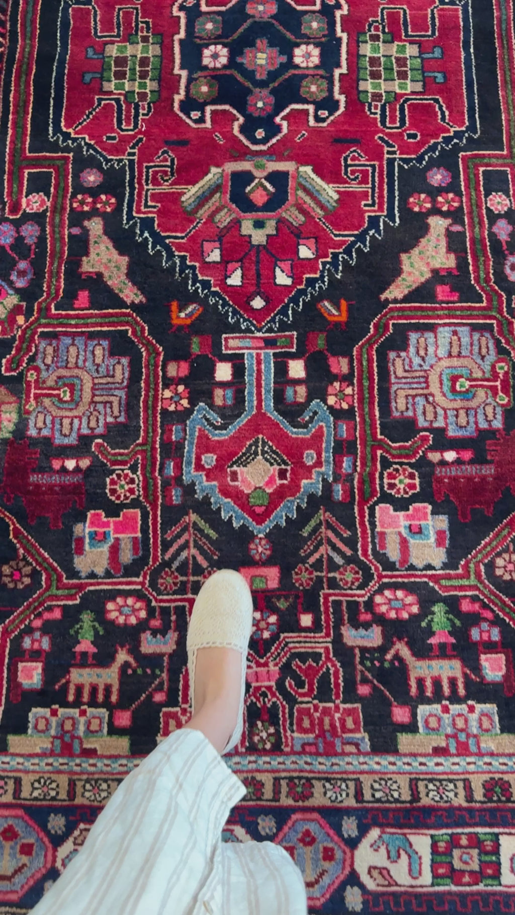 Close-up of the Hand-Knotted Vintage Wool Area Rug – 10' 2" x 5' 6" highlighting detailed animal and floral motifs in vibrant red and navy hues.