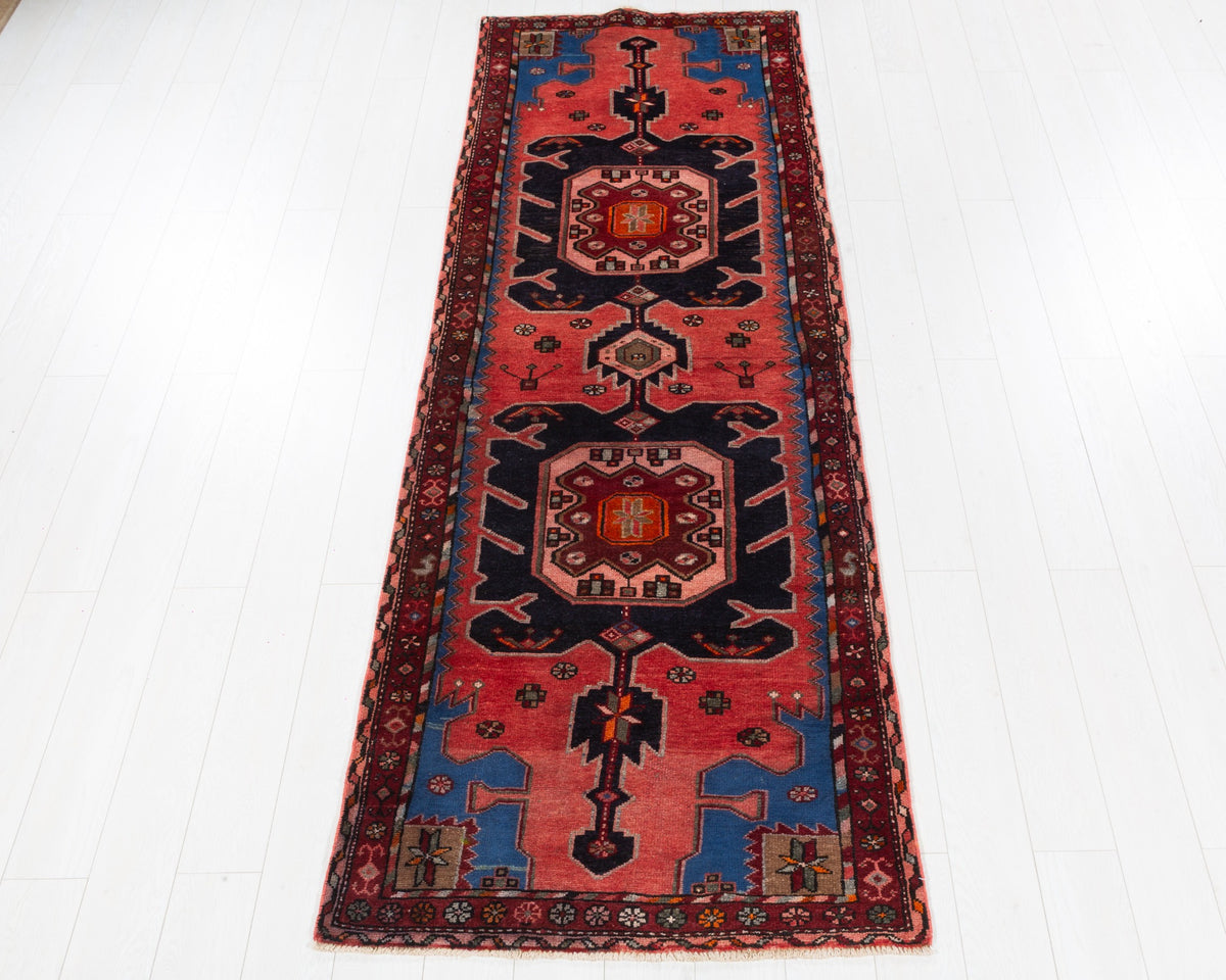 Vintage Hamadan runner with coral-red field and paired deep navy animal motifs, SKU 5157